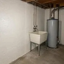 Concrete basement foundation walls painted off-white with masonry primer