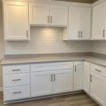Kitchen cabinets painted bright white with a tile backsplash in Kelowna