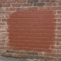 Brick wall in Kelowna repainted to match after graffiti removal