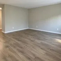 Living room walls painted greige with clean white baseboards in a Kelowna home