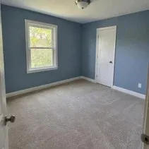 Bedroom repainted muted blue with white door casing