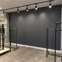 Retail accent wall painted charcoal under track lighting