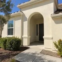 Stucco house exterior in Kelowna repainted warm cream with elastomeric coating