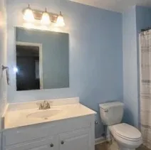 Bathroom wall repainted pale blue after wallpaper stripping